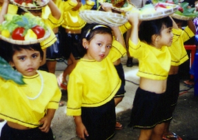 Girls holding baskets of fruit on their heads during the BLC Nutrition Day