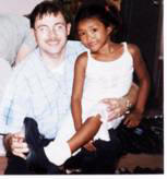 Pastor Paul with a student showing off her new white shoes.