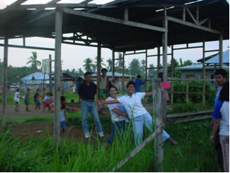 People in open building in field.